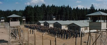 Movie still from “The Great Escape” (1963), directed by John Sturges – A large group of men standing next to each other in a field; Extreme Wide shot, High angle