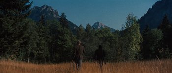 Movie still from “The Great Escape” (1963), directed by John Sturges – A man and a woman are walking through a field; Extreme Wide shot, Low angle