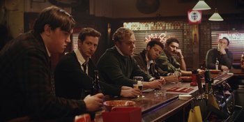 Movie still from “The Greatest Beer Run Ever” (2022), directed by Peter Farrelly – A group of men sitting at a bar drinking beer; Medium shot, Low angle