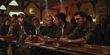 Movie still from “The Greatest Beer Run Ever” (2022), directed by Peter Farrelly – A group of men sitting at a table in front of drinks; Wide shot, Over the shoulder angle
