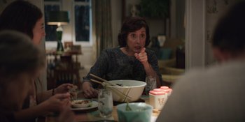 Movie still from “The Greatest Beer Run Ever” (2022), directed by Peter Farrelly – A woman sitting at a table with a bowl of food; Medium shot, Over the shoulder angle
