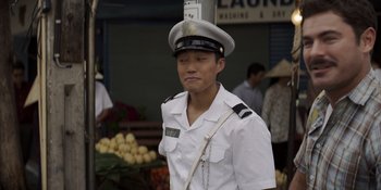 Movie still from “The Greatest Beer Run Ever” (2022), directed by Peter Farrelly – A man in a white uniform is standing in front of a fruit stand; Medium shot, High angle