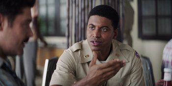 Movie still from “The Greatest Beer Run Ever” (2022), directed by Peter Farrelly – A man in a tan shirt is talking to someone; Close Up shot, Over the shoulder angle