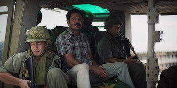 Movie still from “The Greatest Beer Run Ever” (2022), directed by Peter Farrelly – A group of men sitting on a boat in the water; Medium shot, Over the shoulder angle