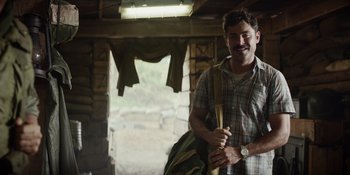 Movie still from “The Greatest Beer Run Ever” (2022), directed by Peter Farrelly – A man standing in a room with a backpack; Medium shot, Over the shoulder angle