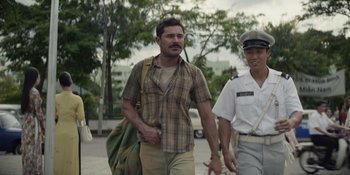 Movie still from “The Greatest Beer Run Ever” (2022), directed by Peter Farrelly – A man walking down a street with a backpack; Medium shot, Over the shoulder angle