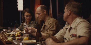 Movie still from “The Greatest Beer Run Ever” (2022), directed by Peter Farrelly – A group of people sitting around a table; Medium shot, Over the shoulder angle