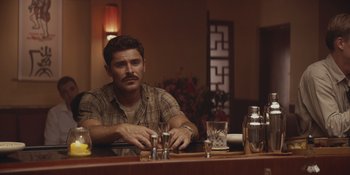 Movie still from “The Greatest Beer Run Ever” (2022), directed by Peter Farrelly – A man sitting at a bar with a drink in front of him; Medium shot, Over the shoulder angle