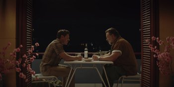 Movie still from “The Greatest Beer Run Ever” (2022), directed by Peter Farrelly – Two men sitting at a table having a conversation; Medium shot, High angle