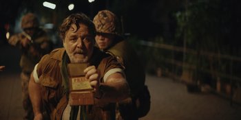 Movie still from “The Greatest Beer Run Ever” (2022), directed by Peter Farrelly – A man with a beard is holding a box of food; Medium shot, Over the shoulder angle