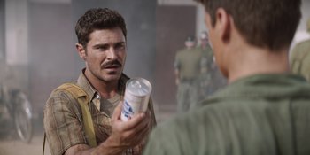 Movie still from “The Greatest Beer Run Ever” (2022), directed by Peter Farrelly – A man is holding a drink in his hand while another man looks on; Close Up shot, Over the shoulder angle