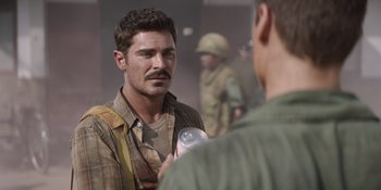 Movie still from “The Greatest Beer Run Ever” (2022), directed by Peter Farrelly – A man holding a bottle talking to another man; Close Up shot, Over the shoulder angle
