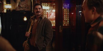 Movie still from “The Greatest Beer Run Ever” (2022), directed by Peter Farrelly – A man with a mustache standing next to a door way; Medium shot, Over the shoulder angle