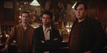 Movie still from “The Greatest Beer Run Ever” (2022), directed by Peter Farrelly – A group of men standing next to each other in front of a bar; Medium shot, Low angle