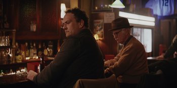 Movie still from “The Greatest Beer Run Ever” (2022), directed by Peter Farrelly – Two men sitting at a table in front of a window; Medium shot, Over the shoulder angle