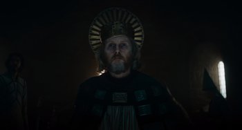 Movie still from “The Green Knight” (2021), directed by David Lowery – A man with a beard wearing a crown; Close Up shot, Low angle