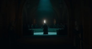 Movie still from “The Green Knight” (2021), directed by David Lowery – A person is standing in the middle of an audience; Extreme Wide shot, Low angle