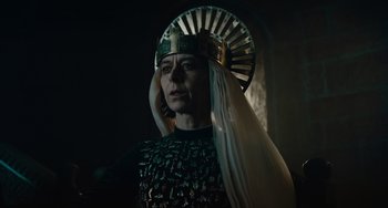 Movie still from “The Green Knight” (2021), directed by David Lowery – A man wearing a crown and a suit of armor; Close Up shot, Low angle