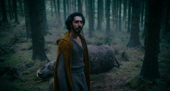 Movie still from “The Green Knight” (2021), directed by David Lowery – A man standing in the middle of a forest; Medium shot, Low angle