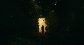 Movie still from “The Green Knight” (2021), directed by David Lowery – A person standing in the middle of a forest; Extreme Wide shot, Low angle
