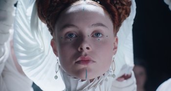 Movie still from “The Green Knight” (2021), directed by David Lowery – A young woman with blue eyes wearing a white dress; Close Up shot, Low angle