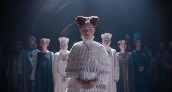 Movie still from “The Green Knight” (2021), directed by David Lowery – A group of people standing in a room; Medium shot, Low angle