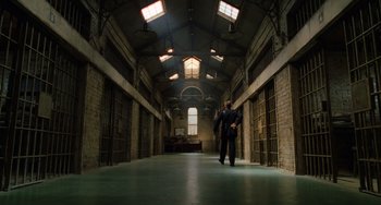 Movie still from “The Green Mile” (1999), directed by Frank Darabont – A man in a suit walks through a jail cell; Extreme Wide shot, Low angle