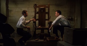 Movie still from “The Green Mile” (1999), directed by Frank Darabont – Two men sitting in front of an electric chair; Medium shot, High angle