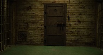 Movie still from “The Green Mile” (1999), directed by Frank Darabont – An old metal door in the middle of a brick wall; Wide shot, High angle