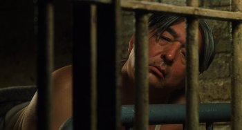Movie still from “The Green Mile” (1999), directed by Frank Darabont – A man with his eyes closed leaning against the bars of a jail cell; Close Up shot, High angle