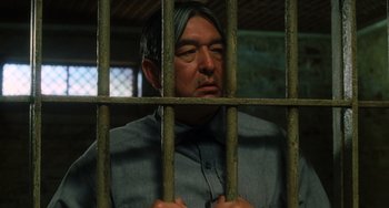 Movie still from “The Green Mile” (1999), directed by Frank Darabont – A man in a jail cell behind bars looking sad; Close Up shot, Low angle