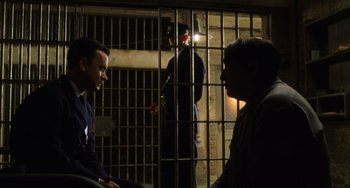 Movie still from “The Green Mile” (1999), directed by Frank Darabont – Two men are sitting next to each other in front of a jail cell; Medium shot, Over the shoulder angle