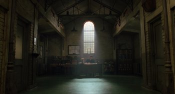 Movie still from “The Green Mile” (1999), directed by Frank Darabont – A man sitting at a desk in a room with a large window; Extreme Wide shot, Low angle