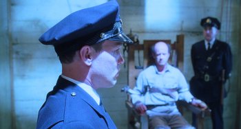 Movie still from “The Green Mile” (1999), directed by Frank Darabont – A man in a prison uniform and a man in a jail cell; Medium shot, Over the shoulder angle