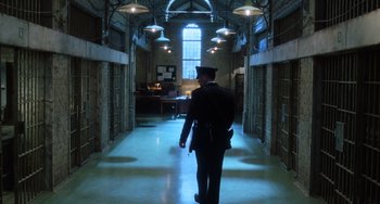 Movie still from “The Green Mile” (1999), directed by Frank Darabont – A man in a uniform walking down a hall way; Wide shot, Low angle
