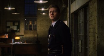 Movie still from “The Green Mile” (1999), directed by Frank Darabont – A man in a police uniform standing in a room; Medium shot, Low angle