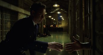 Movie still from “The Green Mile” (1999), directed by Frank Darabont – A man in a suit is shaking hands with another man in a prison cell; Medium shot, Over the shoulder angle