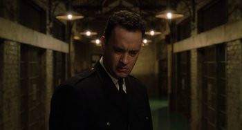 Movie still from “The Green Mile” (1999), directed by Frank Darabont – A man in a suit and tie standing in a room; Close Up shot, Low angle