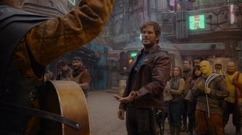 Movie still from “The Guardians of the Galaxy Holiday Special” (2022), directed by James Gunn – A group of people standing around a building; Medium shot, Over the shoulder angle