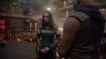Movie still from “The Guardians of the Galaxy Holiday Special” (2022), directed by James Gunn – A woman in a green dress standing next to a man in a leather jacket; Medium shot, Over the shoulder angle