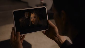 Movie still from “The Guardians of the Galaxy Holiday Special” (2022), directed by James Gunn – A person holding up a cell phone with a picture of a man and a woman on the screen; Extreme Close Up shot, Over the shoulder angle