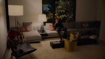 Movie still from “The Guardians of the Galaxy Holiday Special” (2022), directed by James Gunn – A man sitting on a couch in front of a laptop computer; Wide shot, High angle