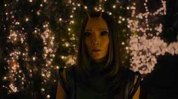 Movie still from “The Guardians of the Galaxy Holiday Special” (2022), directed by James Gunn – A woman with a bunny ears is standing in front of some lights; Close Up shot, Over the shoulder angle