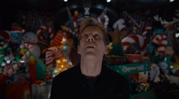 Movie still from “The Guardians of the Galaxy Holiday Special” (2022), directed by James Gunn – A man in a black shirt is standing in front of christmas decorations; Close Up shot, Low angle
