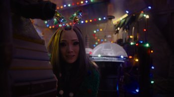 Movie still from “The Guardians of the Galaxy Holiday Special” (2022), directed by James Gunn – A woman wearing a green sweater with lights in the background; Close Up shot, Over the shoulder angle
