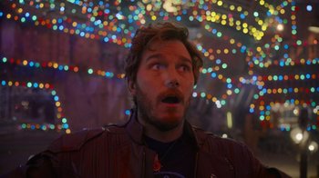 Movie still from “The Guardians of the Galaxy Holiday Special” (2022), directed by James Gunn – A person looking up with lights in the background; Close Up shot, Over the shoulder angle
