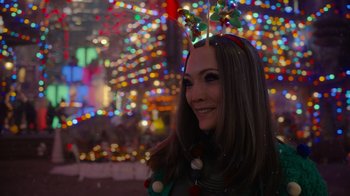 Movie still from “The Guardians of the Galaxy Holiday Special” (2022), directed by James Gunn – A woman wearing a headband and smiling for the camera; Close Up shot, Over the shoulder angle
