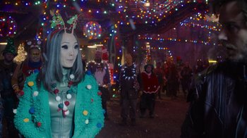 Movie still from “The Guardians of the Galaxy Holiday Special” (2022), directed by James Gunn – A group of people standing in a room with christmas lights; Close Up shot, Over the shoulder angle