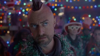 Movie still from “The Guardians of the Galaxy Holiday Special” (2022), directed by James Gunn – A man with a mohawk is standing in front of a crowd; Close Up shot, Over the shoulder angle
