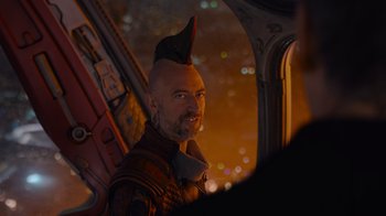 Movie still from “The Guardians of the Galaxy Holiday Special” (2022), directed by James Gunn – A man with a red hat is looking out a window; Close Up shot, Over the shoulder angle